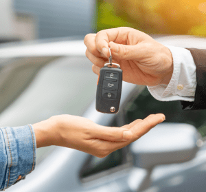 a person handing over a car key